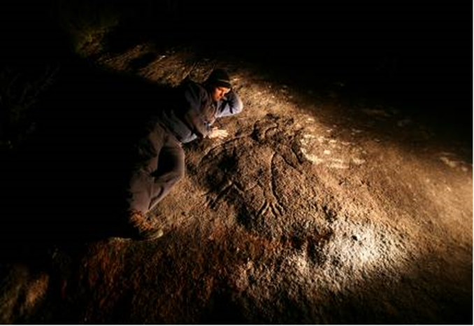 Matthew Kelleher next to a life-size eagle engraving, Gallery Rock (photo by Tristram Miller).