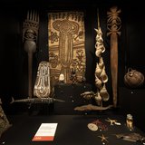 Mother and Child Case. In the centre of the showcase, is a sculpture of a seated mother and child. Made in the Solomon Islands in the 1920s, it has a more realistic style than traditional Solomon carvings. The young boy has paler skin than the woman and may represent a local light-skinned baby or possibly the child of a white settler with his nanny.