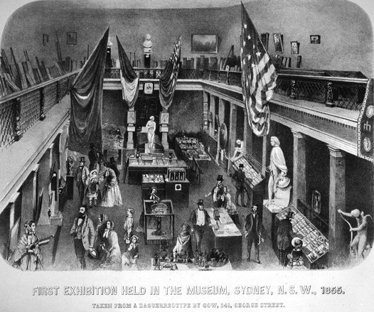 A black and white illustration of a large exhibition hall filled with visitors and display cases