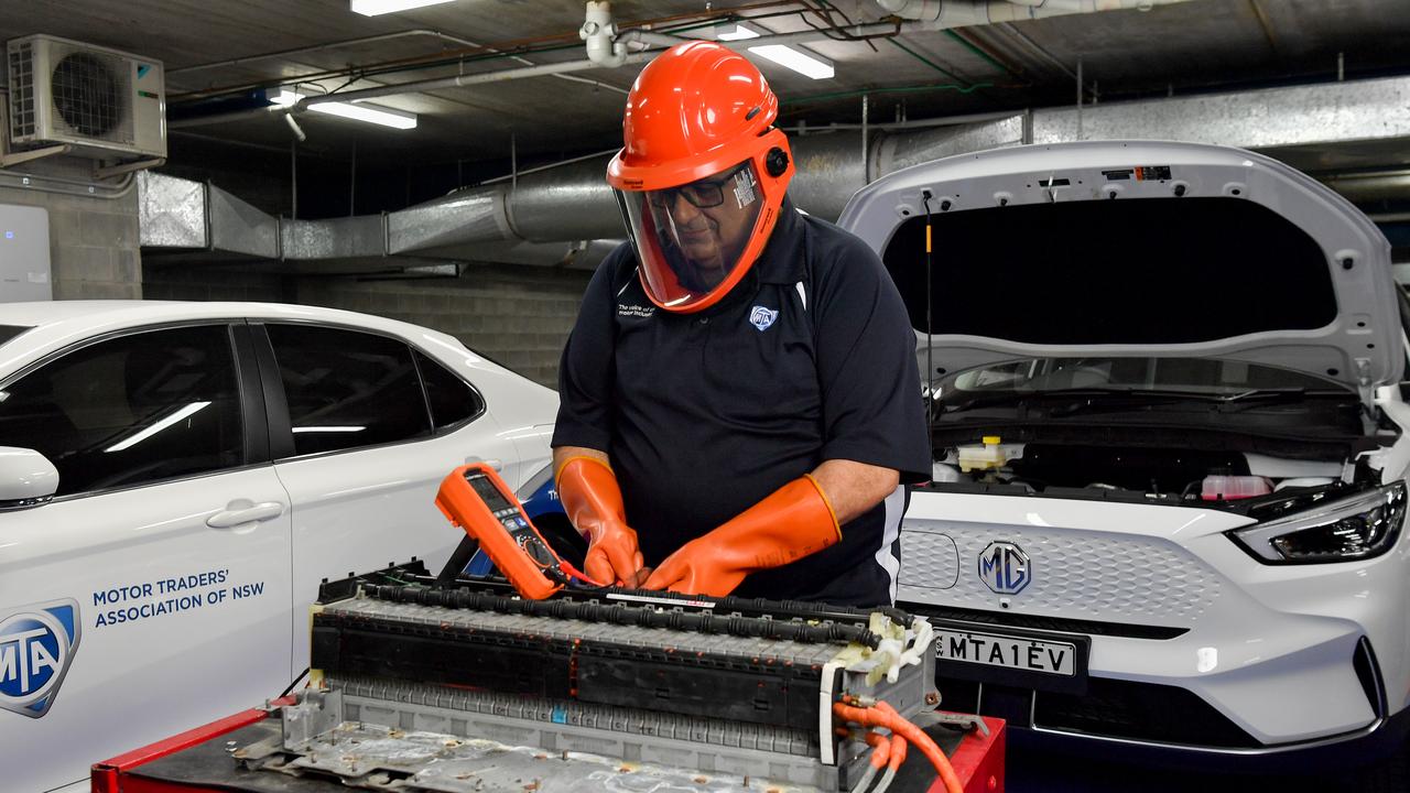 Man works on the battery of an MG electric car in Sydney