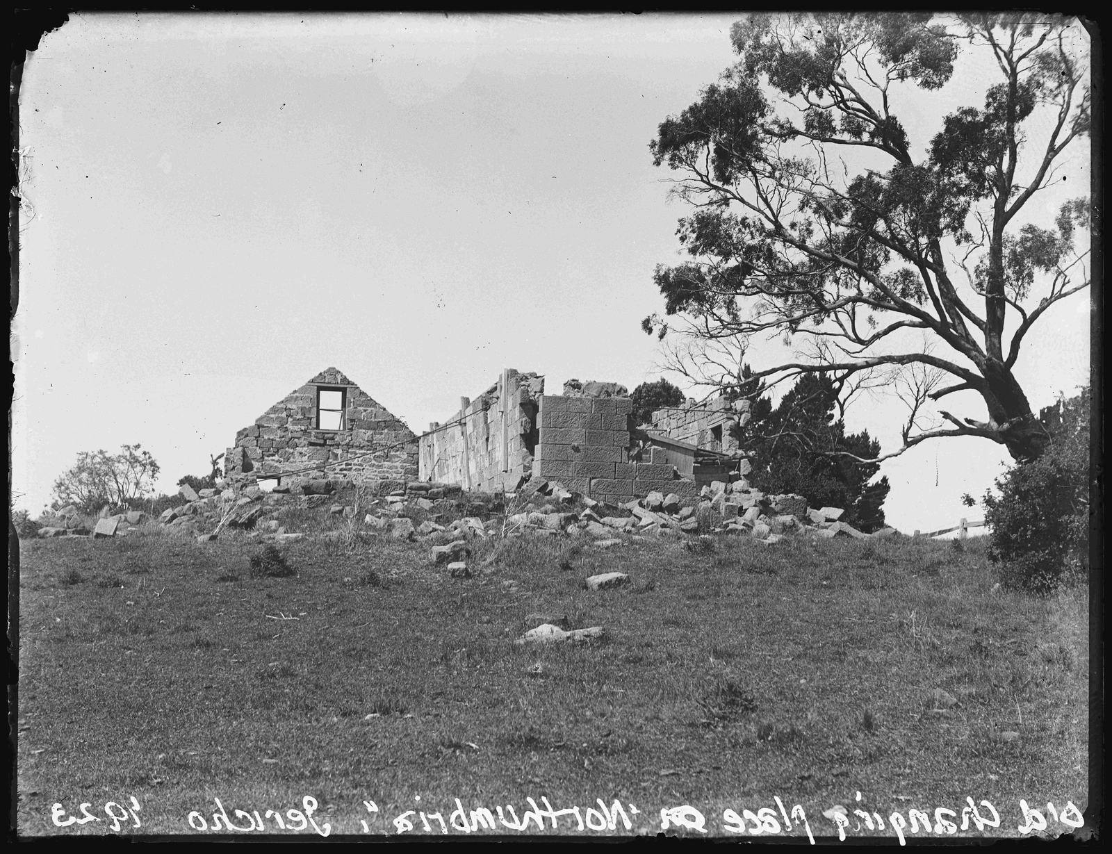 Black and white photograph of ruins sitting on top of a hill.