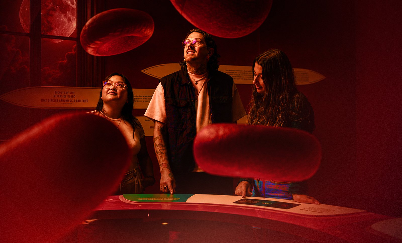 Three adults explore the Bloodsuckers: Nature's Vampires exhibition at the Australian Museum.