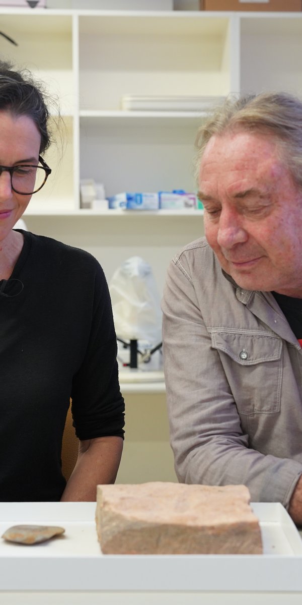 Dr Amy Mosig Way and Wayne Brennan with 8,500 year old basalt nut_seed cracking anvil and 13,000 year old portable grinding stone used to shape bone or wooden artefacts such as needles, awls, bone points and nose points. Photo Laura Martin