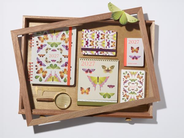 2027 diary and notebook range in butterfly print, arranged in wooden specimen tray with magnifying glass and calliper.