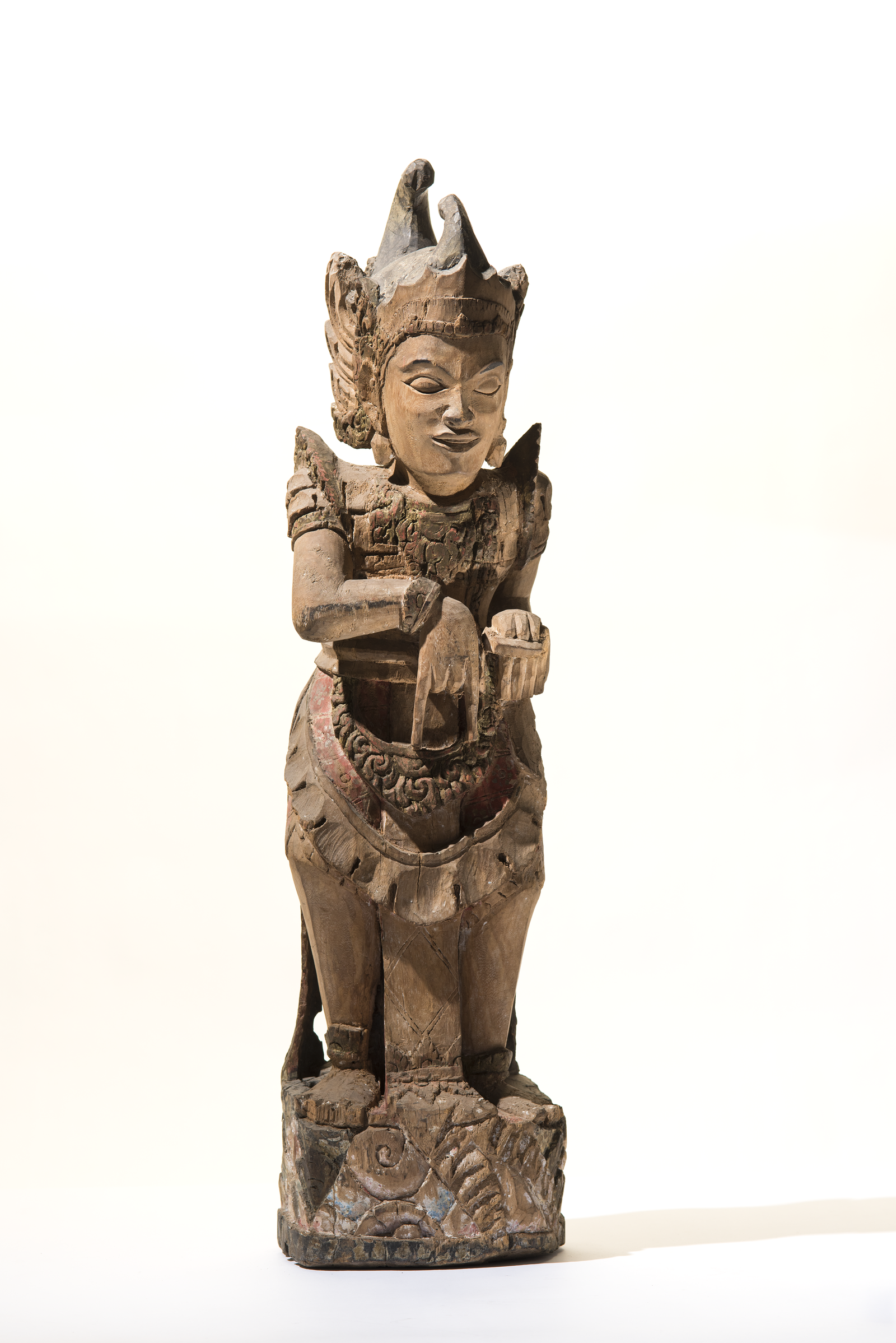Carved wooden figure of Arjuna, a Hindu deity, wearing an elaborate crown and decorative regalia.