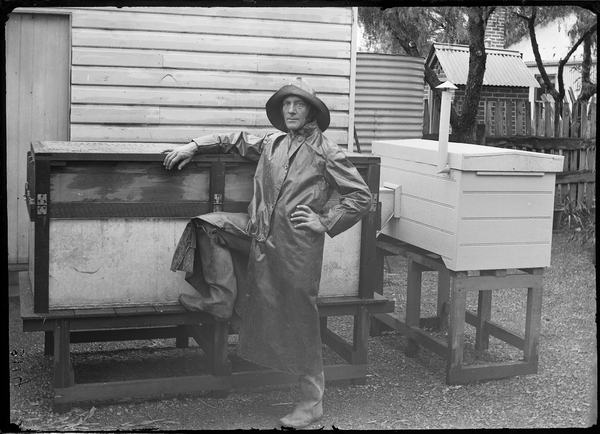 Harry Burrell standing beside a large wooden platypus enclosure.