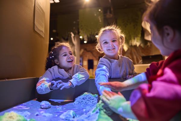 Kids playing around an interactive tabletop display.