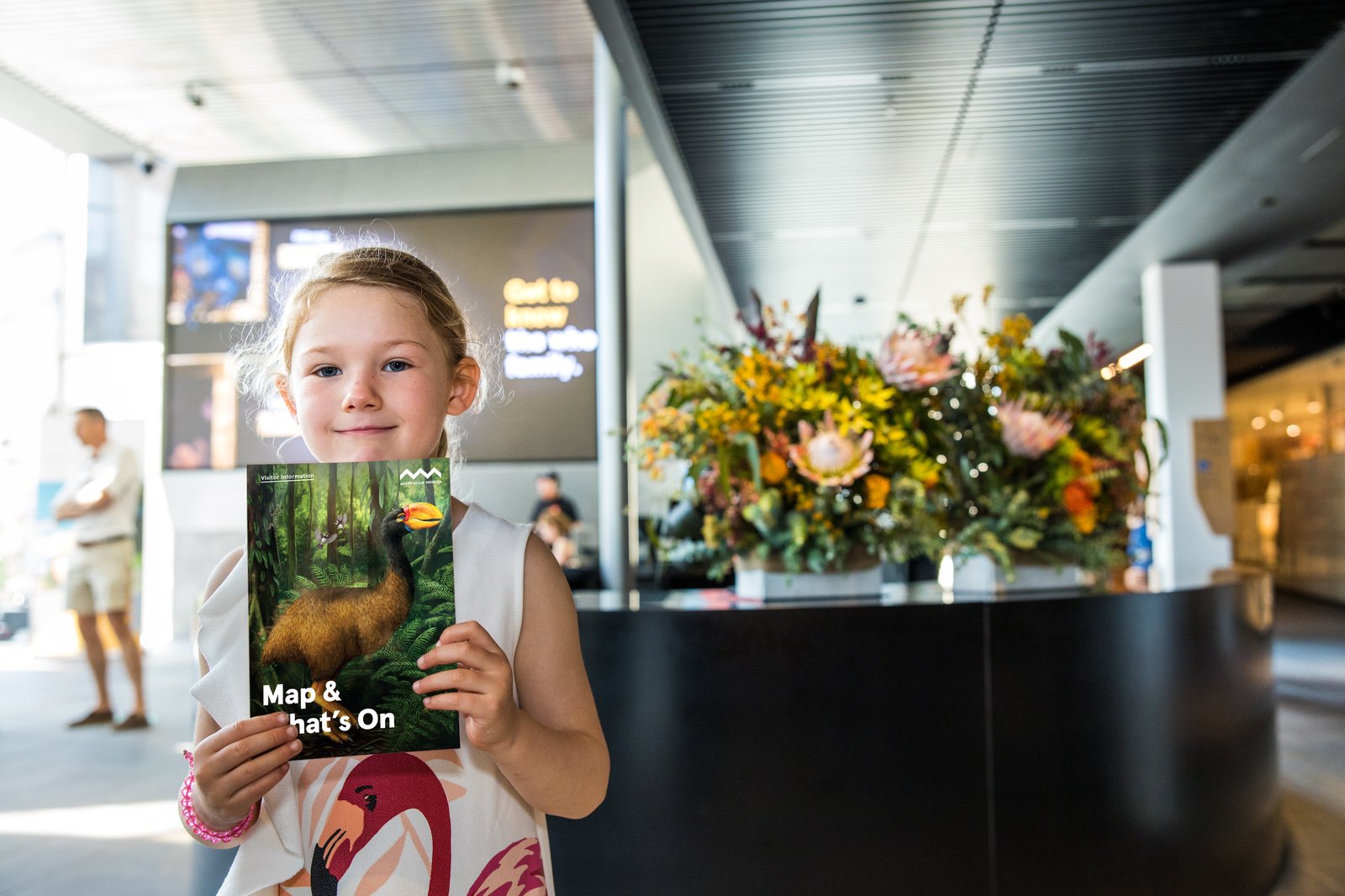 Child holding Australian Museum What's On calendar and map in Crystal Hall.