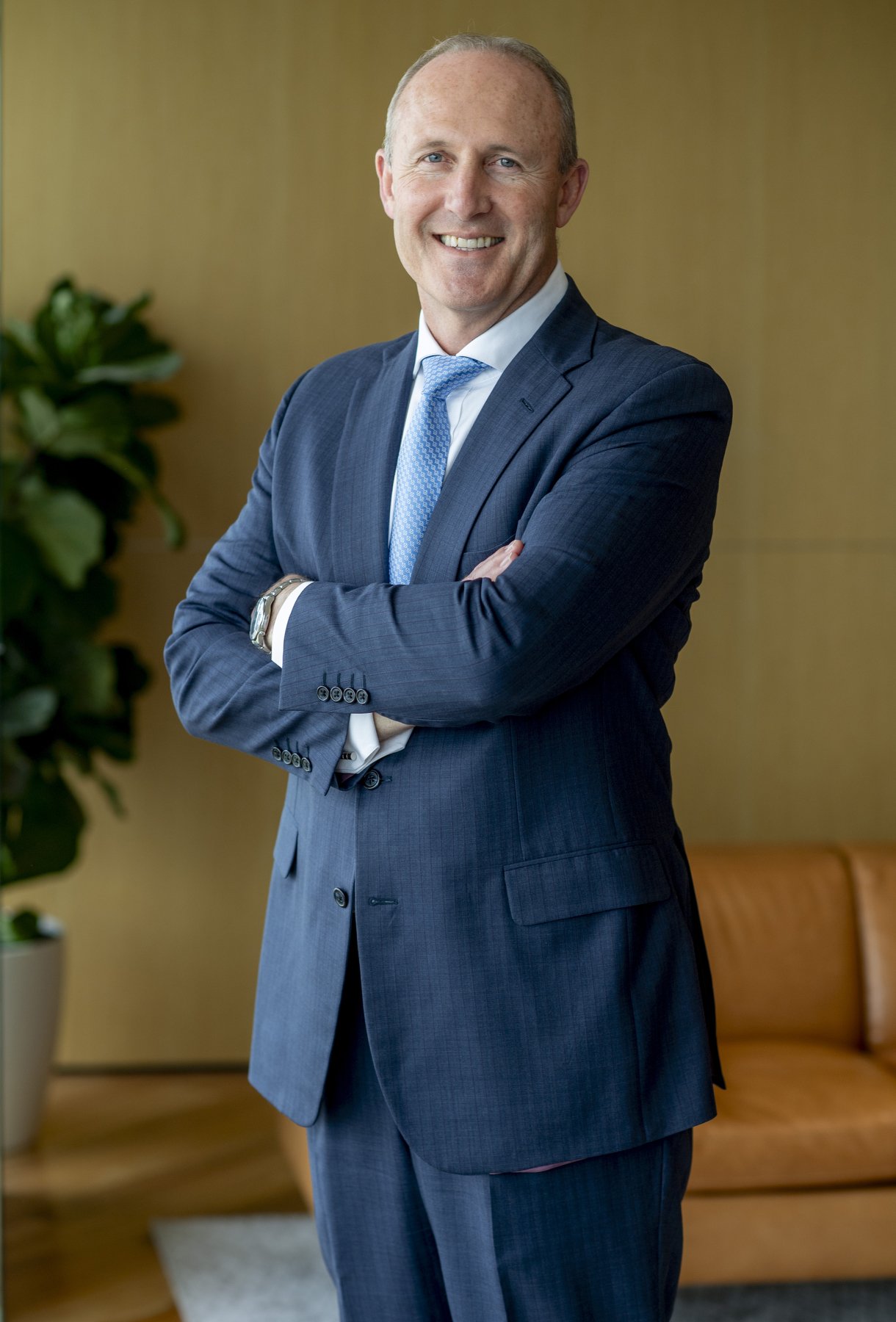 Portrait of Michael Chisholm in a suit with arms folded
