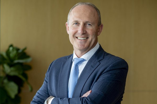 Portrait of Michael Chisholm in a suit with arms folded
