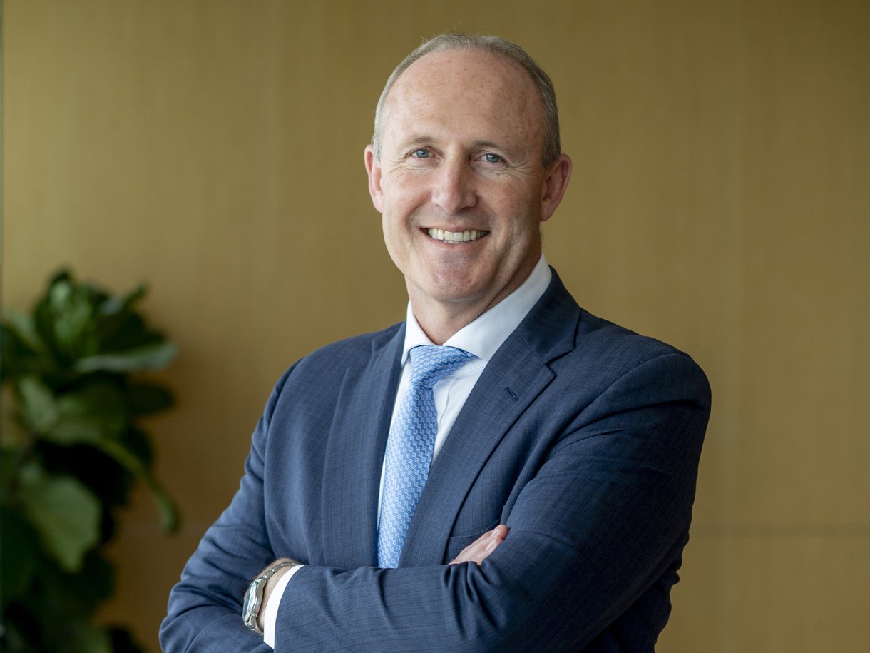 Portrait of Michael Chisholm in a suit with arms folded