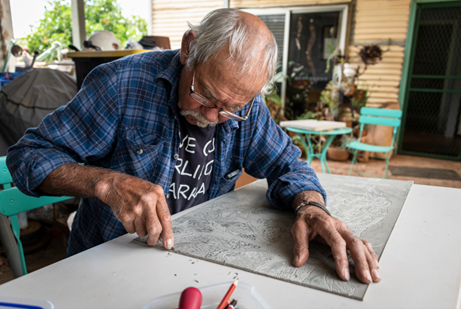 Uncle Badger Bates working on linocut (2022).
