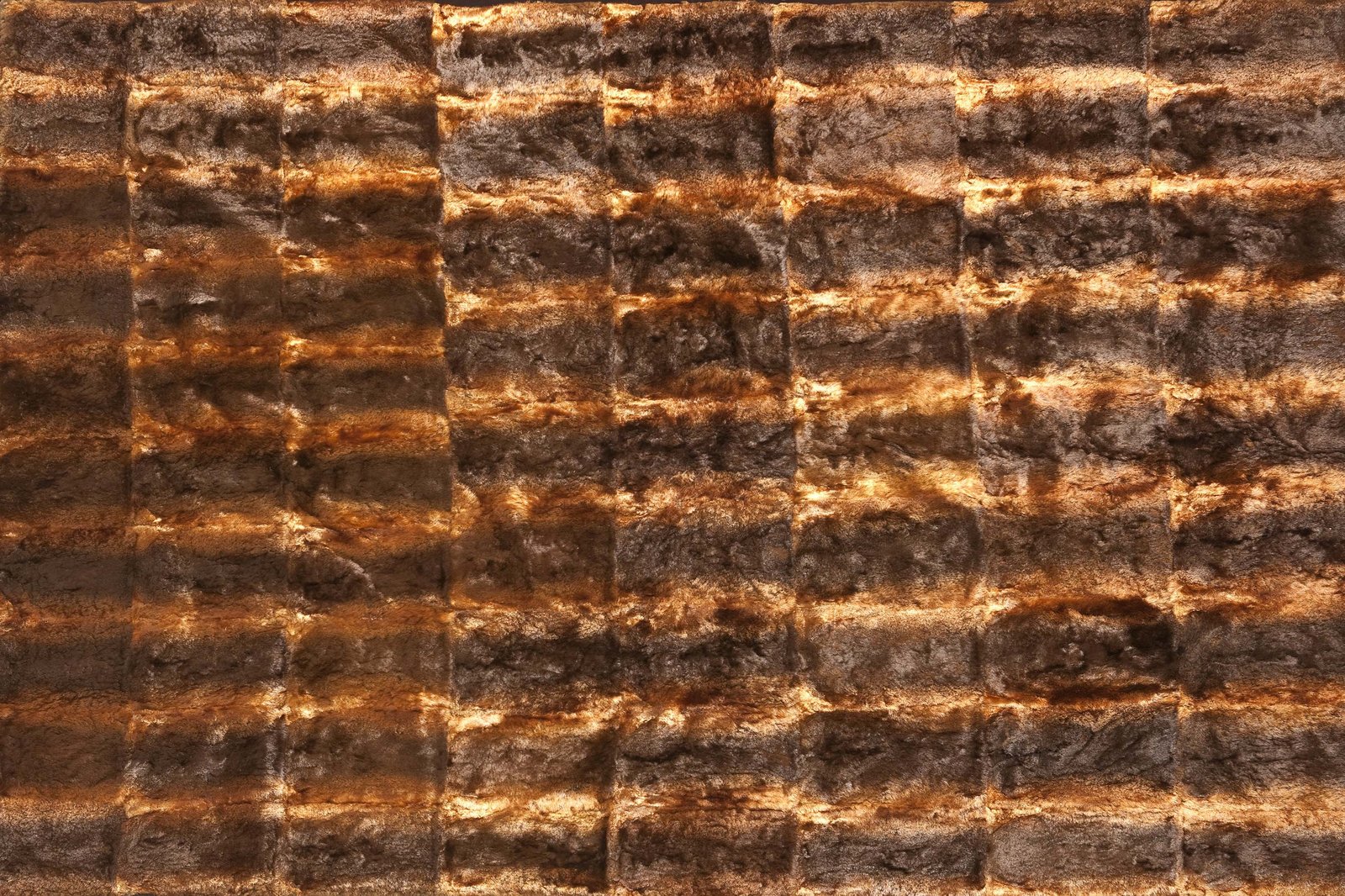 A rug made from 75 platypus skins sewn together in dark brown horizontal rows.