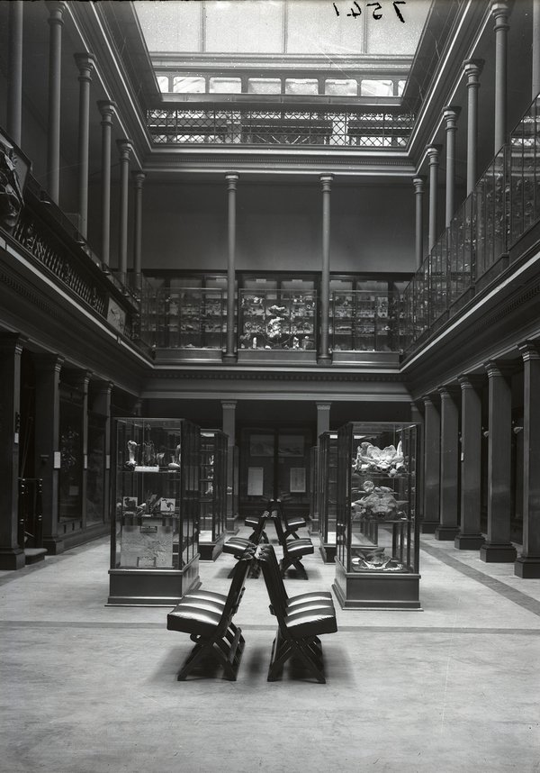 A black and white photograph of the Australian Museum's two-level Long Gallery with glass rooftop.