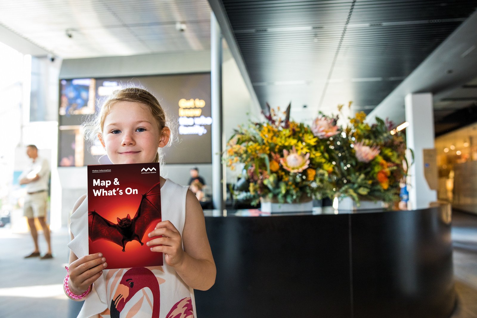 Child holding Australian Museum What's On calendar and map in Crystal Hall.