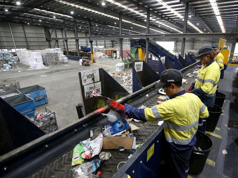 Workers sort waste from domestic recyclables