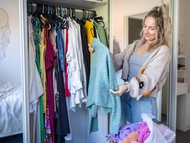 A woman shows off clothes in her wardrobe