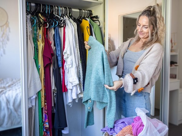 A woman shows off clothes in her wardrobe