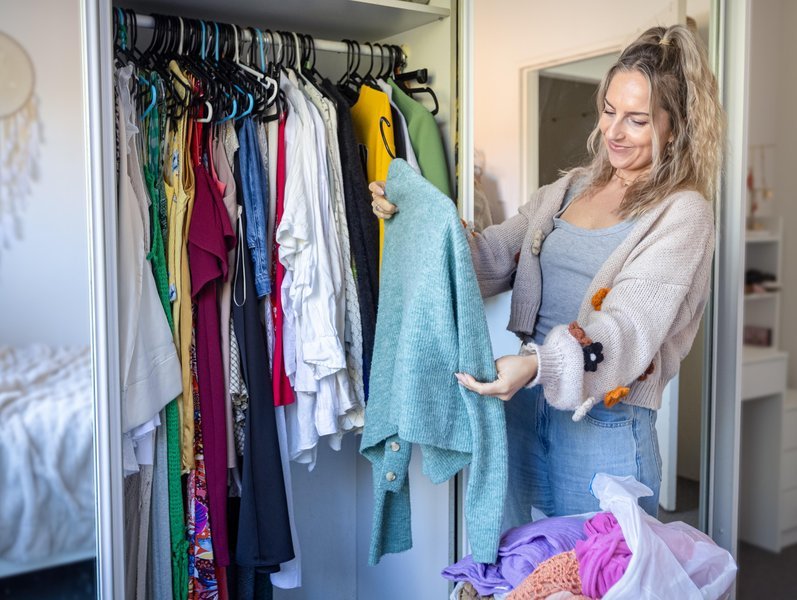 A woman shows off clothes in her wardrobe
