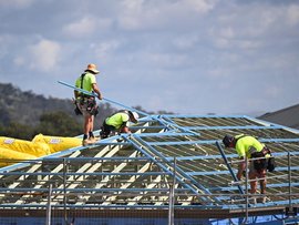 Roofers are seen working at a building site