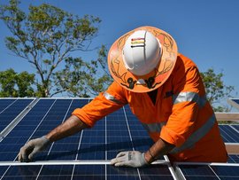 workers install solar panels