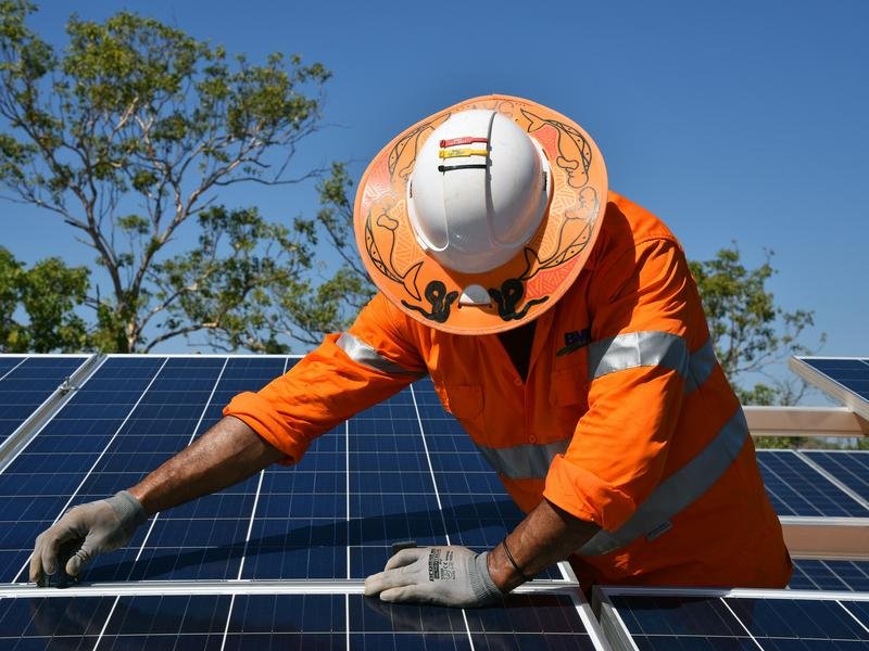 A worker installs solar panels in the NT