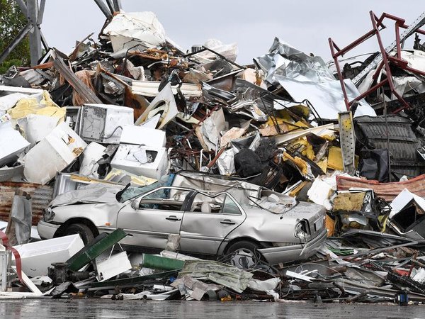 A car is seen amongst waste at a metal recycling business