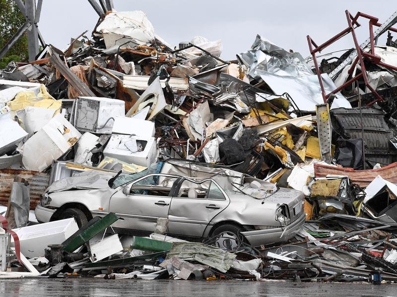 A car is seen amongst waste at a metal recycling business
