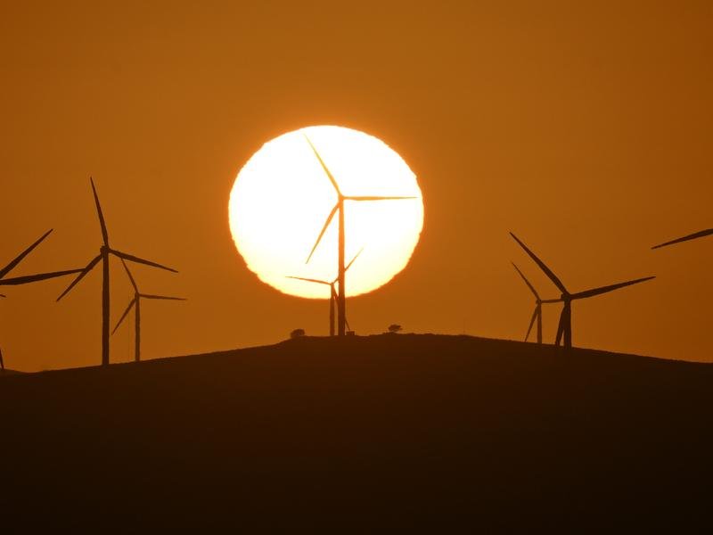 The sun rises over power-generating wind turbines (file image)