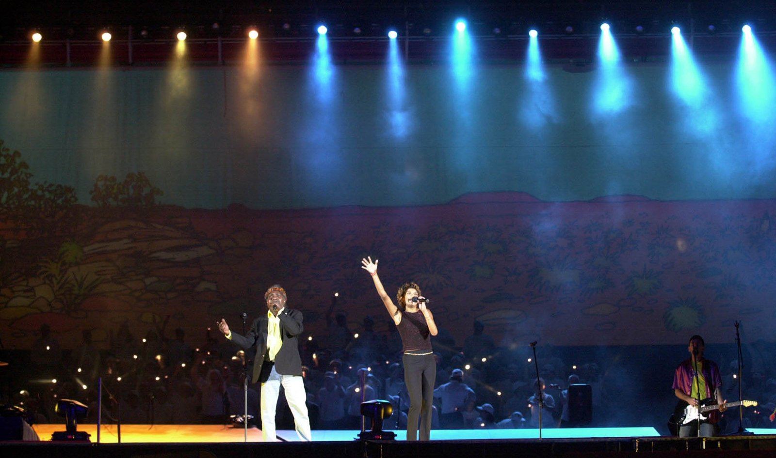 Yunupingu at the Sydney Paralympic Games performing on a stage with lights and musicians in view